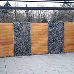 Gabionenzaun mit Holzelementen als Sichtschutz für die Terrasse