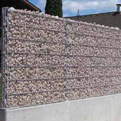 Schmale Steinzaun Mesh mit Fußplatten befestigt auf Betonmauer