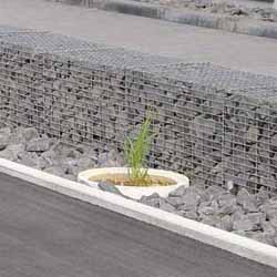Gabionenmauer zur Grundstücksbefestigung mit bepflanzten Steinbeet 