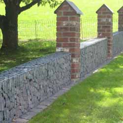 Gabionenzaun kombiniert mit Backsteinsäulen als Gartenmauer